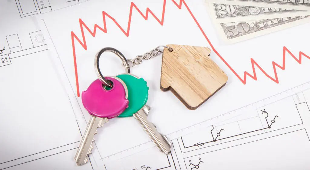 Keys, dollars and downward graphs representing crisis of real estate market. Reduced housing prices
